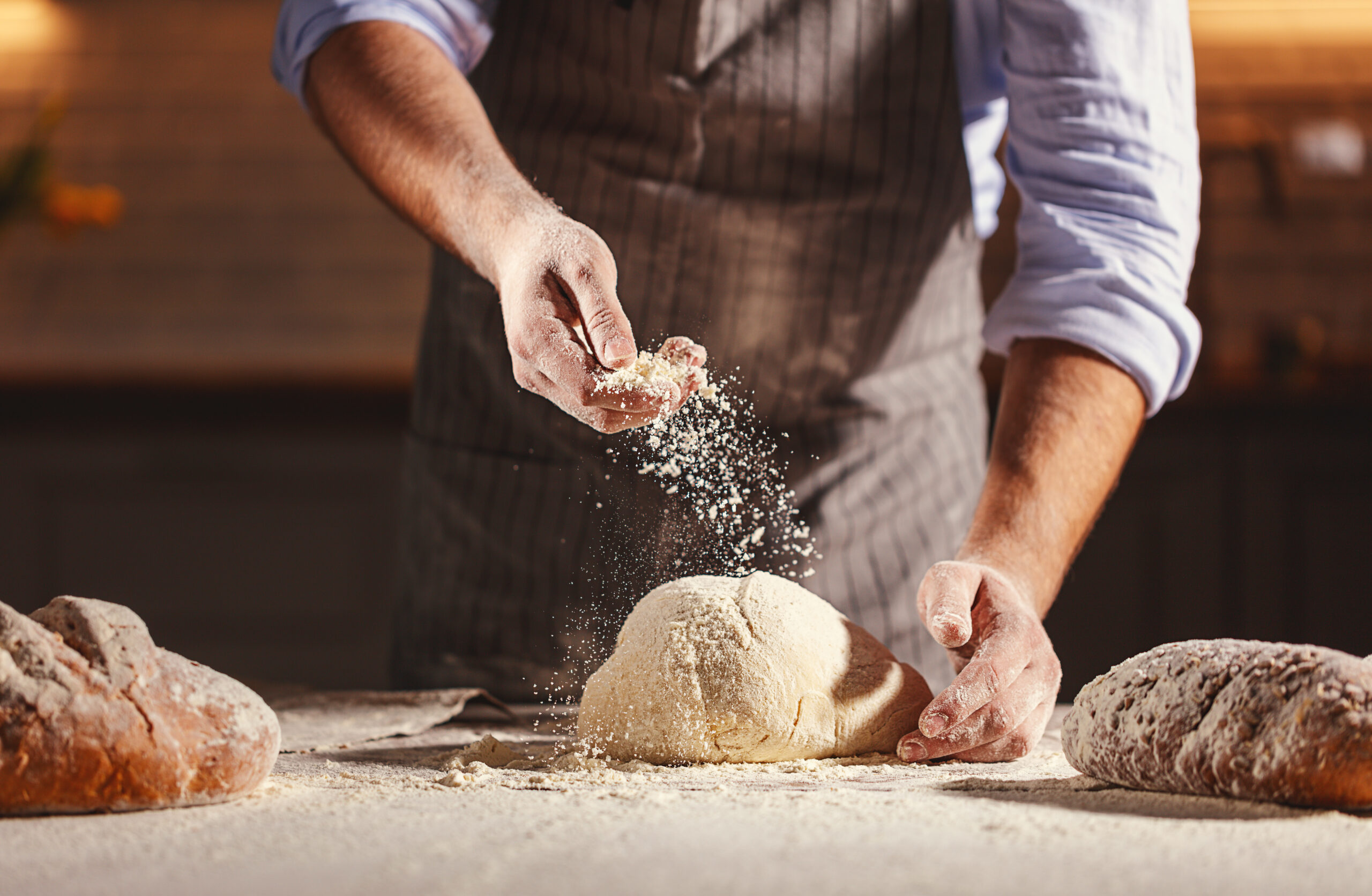 hands of baker’s male knead dough